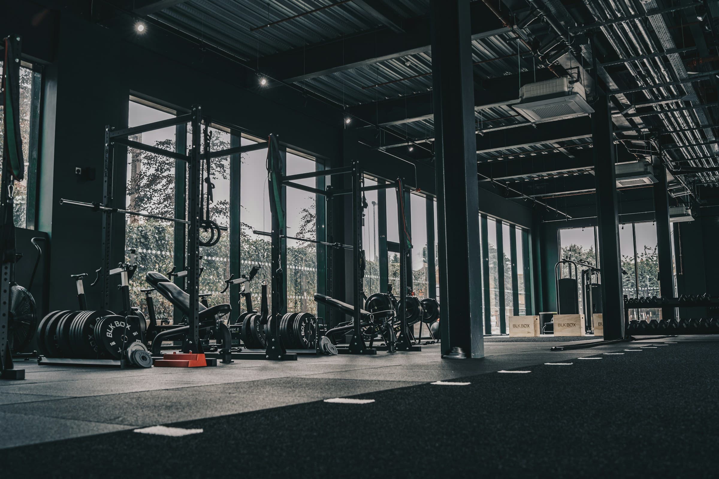 Modern strength-training gym with squat racks, benches, and free weights